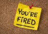 Fired For Defying Trump — Now He Runs THIS! A yellow sticky note pinned to a corkboard with the words 'YOU'RE FIRED' written on it