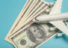 A model airplane placed on top of dollar bills