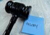 Judge's gavel resting on a blue sticky note