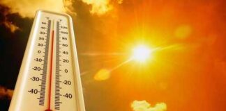 Thermometer displaying high temperature against a bright sun