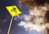 Metal In Dinner — 23,000 Pounds Vanish Yellow skull and crossbones warning sign against smoky sky