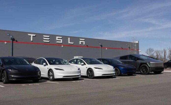 A lineup of Tesla cars parked in front of a Tesla building
