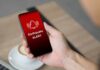 Hand holding a smartphone displaying an earthquake alert notification