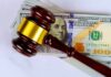 Judge’s gavel on a stack of U.S. hundred-dollar bills