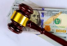 Judge’s gavel on a stack of U.S. hundred-dollar bills