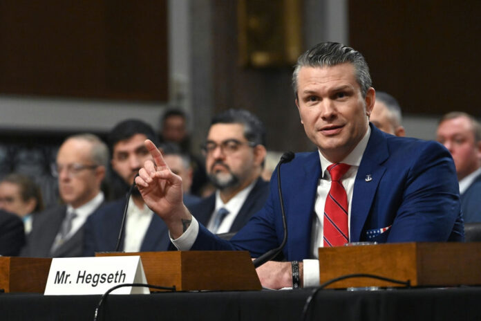 Man in blue suit testifying at a hearing with microphone