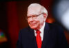 Warren Buffett in a suit and red tie during an interview