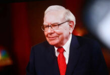 Warren Buffett in a suit and red tie during an interview