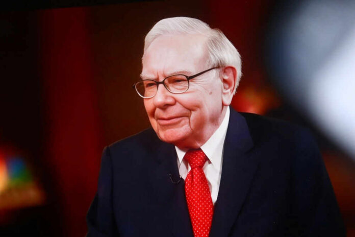 Warren Buffett in a suit and red tie during an interview