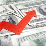 A red arrow indicating growth over scattered hundred dollar bills