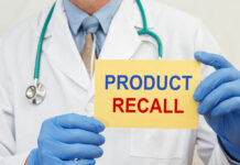 Kids Hit Hard In Food Recall Scare Doctor holding a product recall sign in gloves
