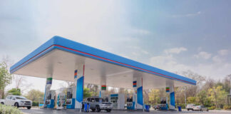 A modern gas station with fuel pumps and parked vehicles