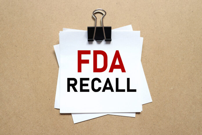 A notice labeled 'FDA RECALL' clipped to white papers on a brown background