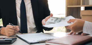 Two individuals engaged in a business transaction involving money and documents