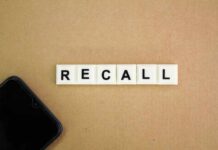 Letter tiles spelling recall on cardboard with a smartphone corner