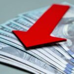 Red downward arrow on U.S. dollar bills