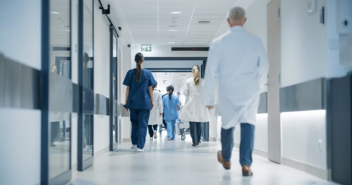 Hospital,Hallway,With,Doctors,,Nurses,And,Specialists,In,Hospital.,Female Medical staff walking through a hospital corridor