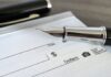 CRAZY: 300,000 Paychecks Abandoned? Close-up of a fountain pen poised over a blank check