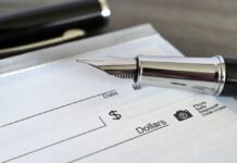 Close-up of a fountain pen poised over a blank check