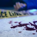 VIDEO: Nurse Killed – Killer Vanishes Blood on pavement with police tape and a hand in the background
