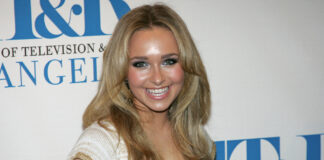 Smiling woman with long blonde hair at a media event