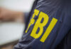 Person wearing FBI jacket, letters in yellow.