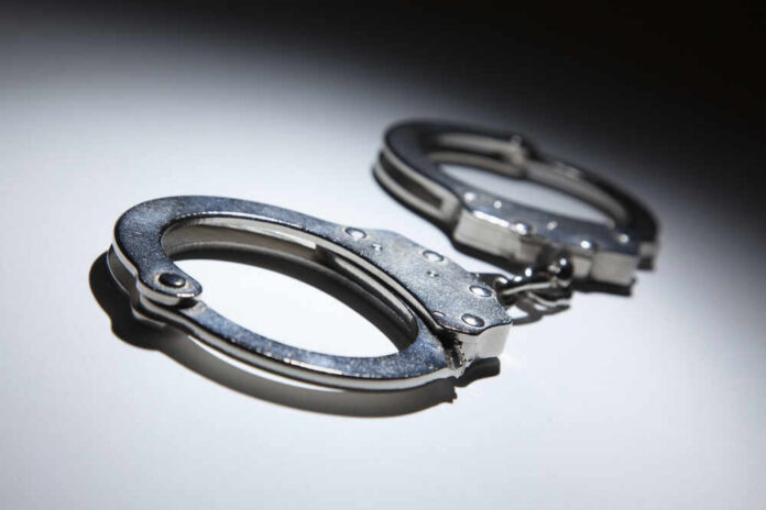 Close-up of metallic handcuffs on a light surface