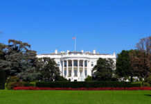 Praise, Then Purge – What Changed? The White House with flags and trees.