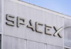 SpaceX building logo against blue sky.