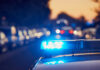 police car light bar flashing on a city street at dusk