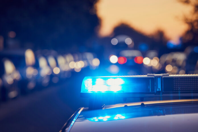 police car light bar flashing on a city street at dusk
