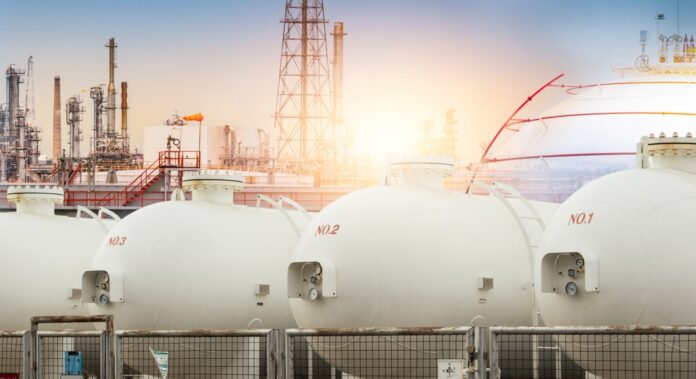 Gas storage tanks in an industrial facility during sunrise