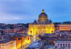 Illuminated St Peters Basilica at dusk Rome skyline