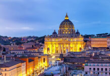 Illuminated St Peters Basilica at dusk Rome skyline