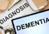 Medical diagnosis paperwork and a tablet displaying the word Dementia