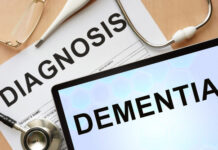 Medical diagnosis paperwork and a tablet displaying the word Dementia