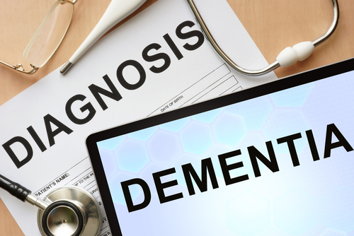 Medical diagnosis paperwork and a tablet displaying the word Dementia