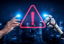 Human and robot hands touch a glowing warning icon