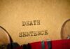 Typewriter typing the words death sentence on paper