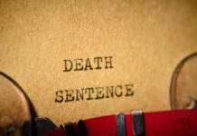Execution Fails Twice – She Kept Breathing Typewriter typing the words death sentence on paper