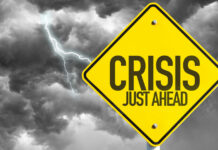 US Orders Exit Over Strikes Yellow sign reading Crisis Just Ahead with stormy sky