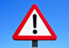 Hundreds Hit in Airport Attack (Video) A triangular warning sign with an exclamation mark against a blue sky